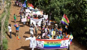 a group of people marching with rainbow flags