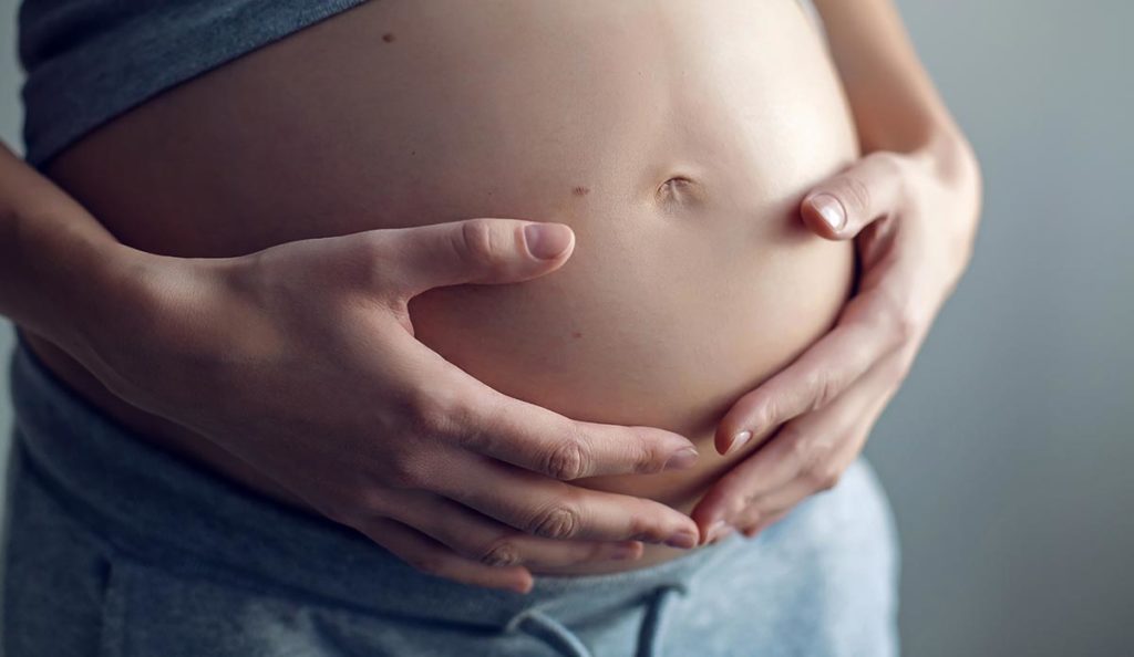 a pregnant woman holding her belly