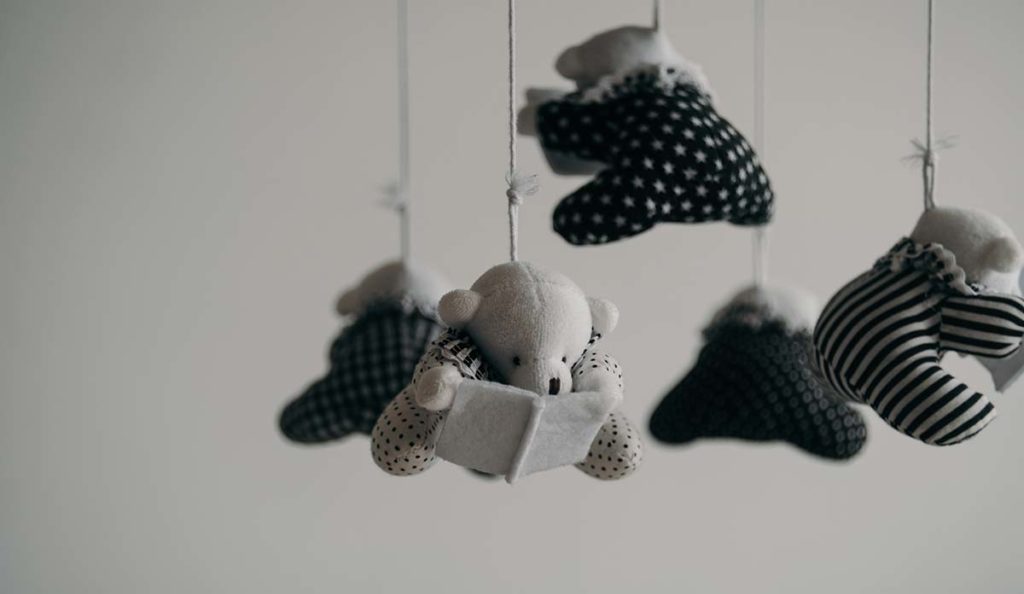 a mobile with teddy bears and a book