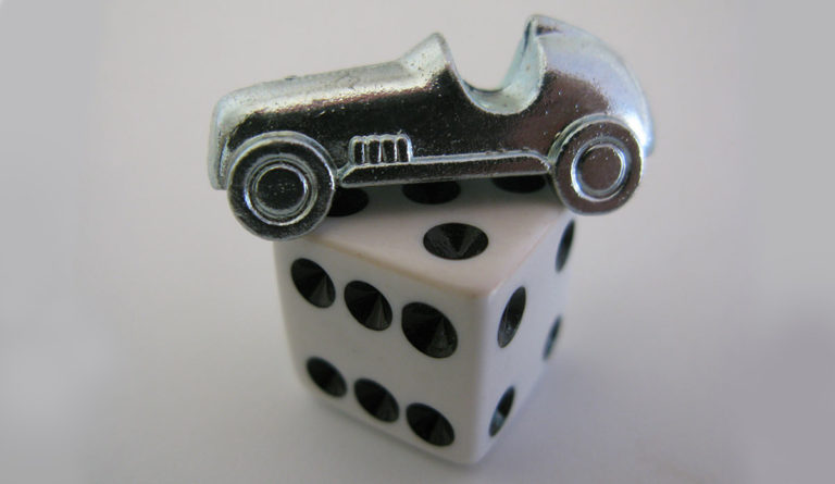 a silver car on top of a white dice
