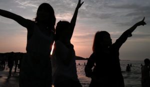 a group of women standing on a beach