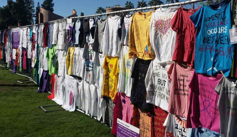 a group of t-shirts on a fence