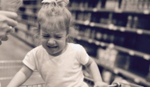 Toddler crying in a grocery cart