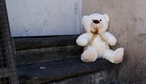 a teddy bear sitting on a stone steps