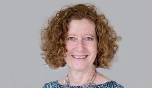 a woman with curly red hair smiling