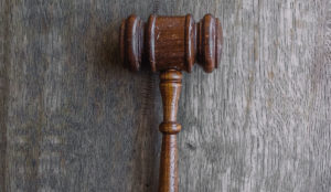 a wooden gavel on a wood surface