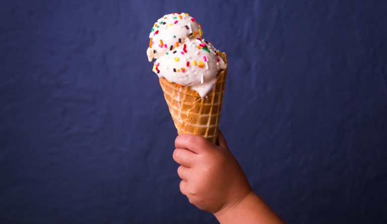 a hand holding a ice cream cone