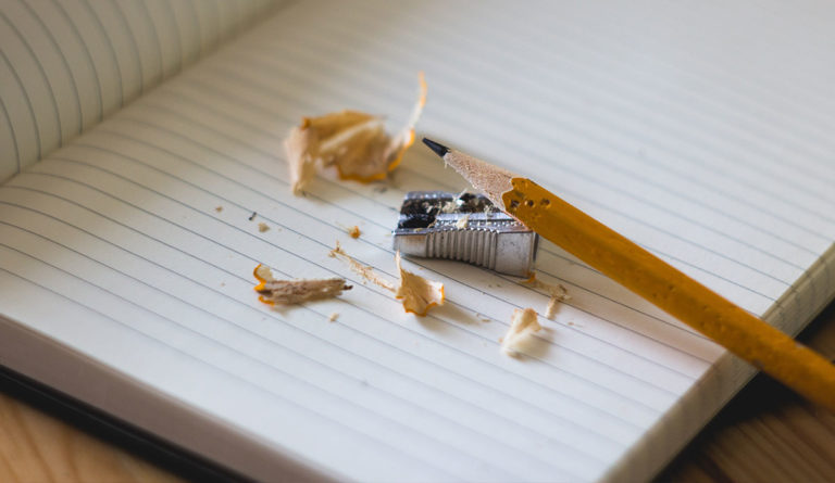 a pencil sharpener and shavings on a notebook