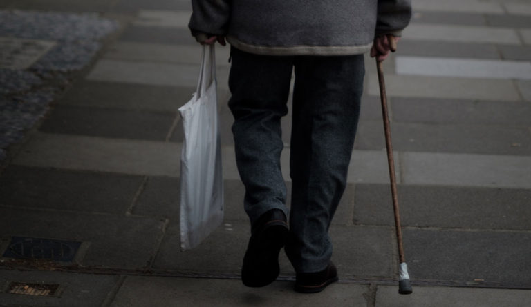 a person holding a cane and a bag
