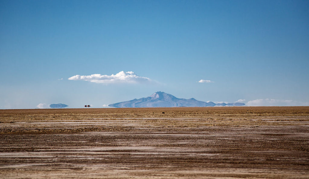 a large flat ground with a mountain in the background