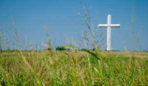 a large white cross in a field of grass