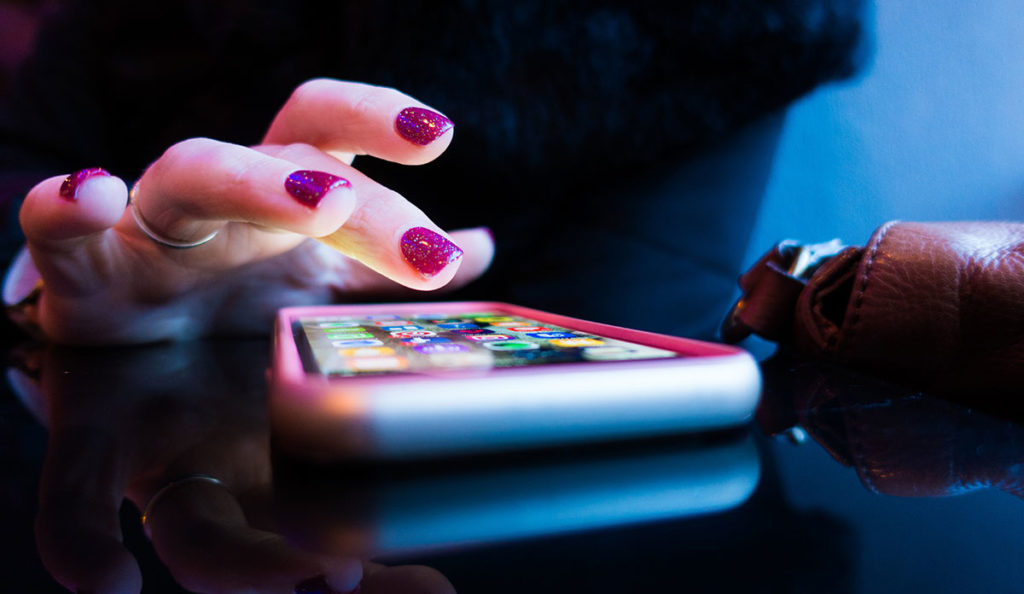 a woman's hand touching a cell phone
