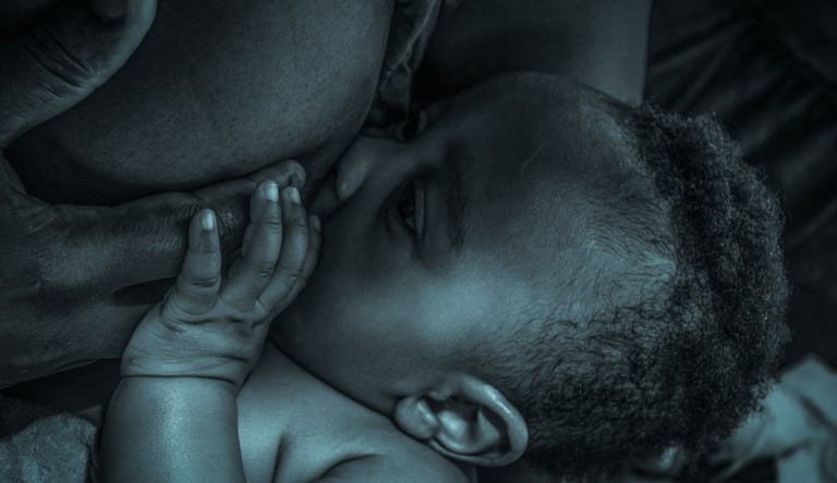 a baby breastfeeding a woman