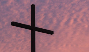a cross against a pink sky