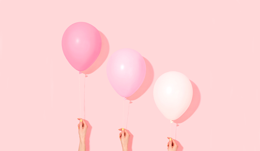 a group of hands holding balloons