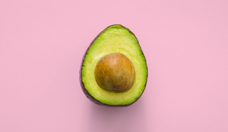 a half of an avocado with a seed in it