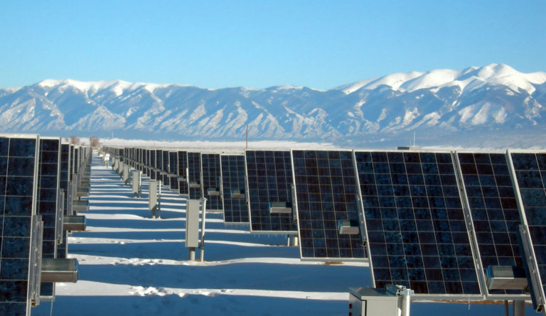 a row of solar panels in a snowy field