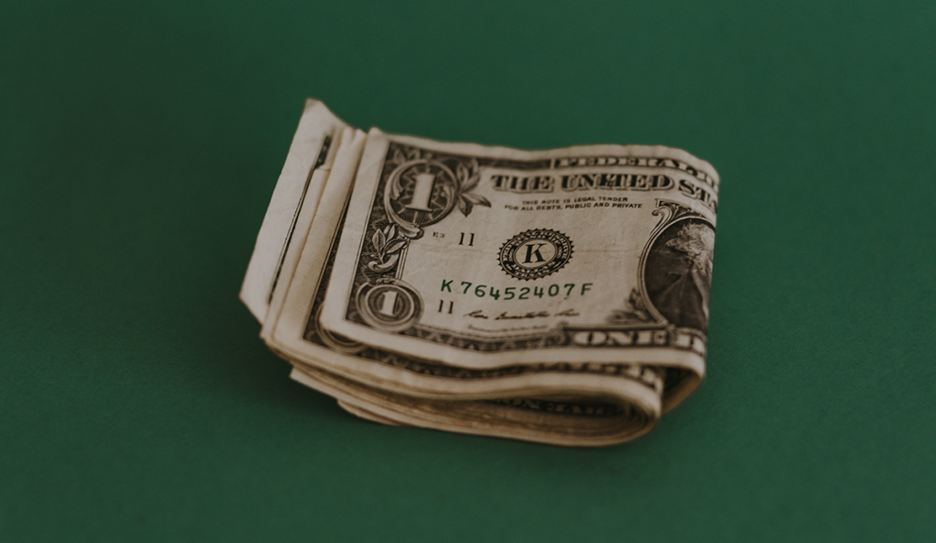 a stack of money on a green surface