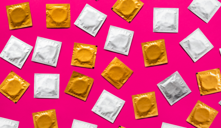 a group of condoms on a pink background