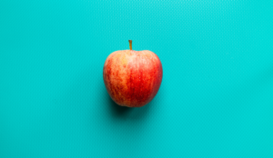 a red apple on a blue surface