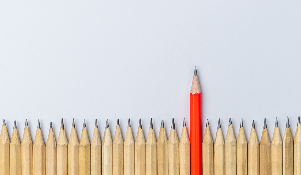 a red pencil standing out from the crowd of pencils