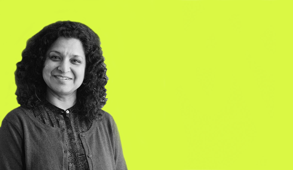 a woman smiling with a yellow background