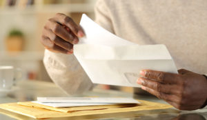 a person opening a white envelope