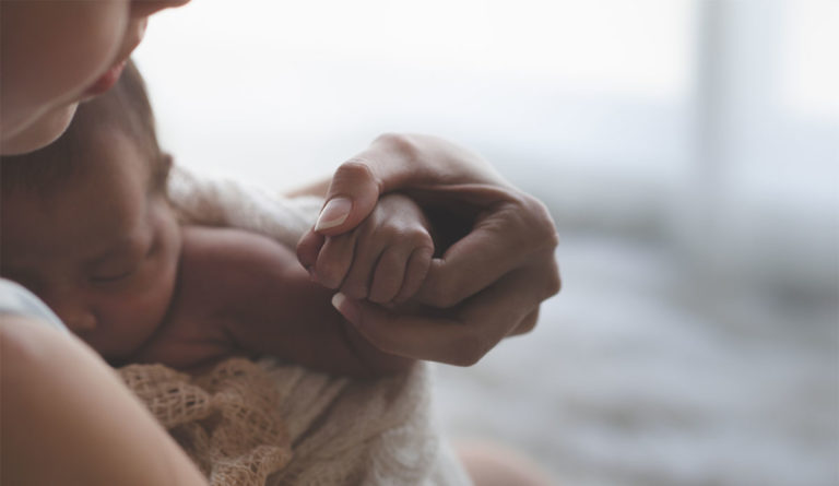 a close up of a hand holding a baby