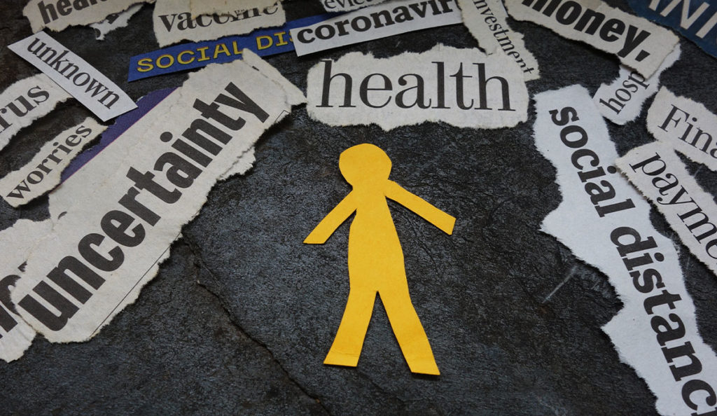 a yellow paper cut out of a person surrounded by newspaper headlines