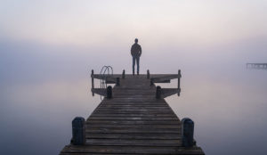 person on pier in fog