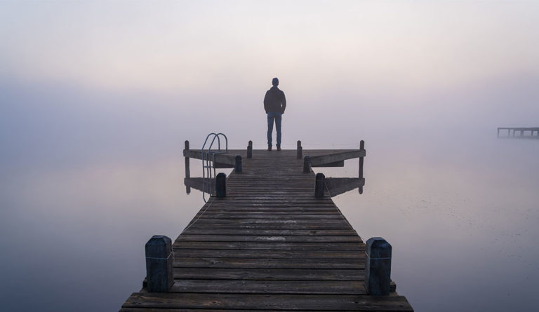 person on pier in fog