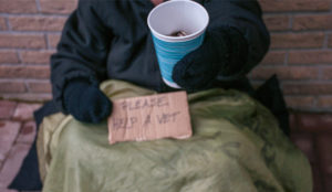 a person holding a cup and a sign