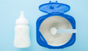 a blue container with a spoon and a bottle of milk