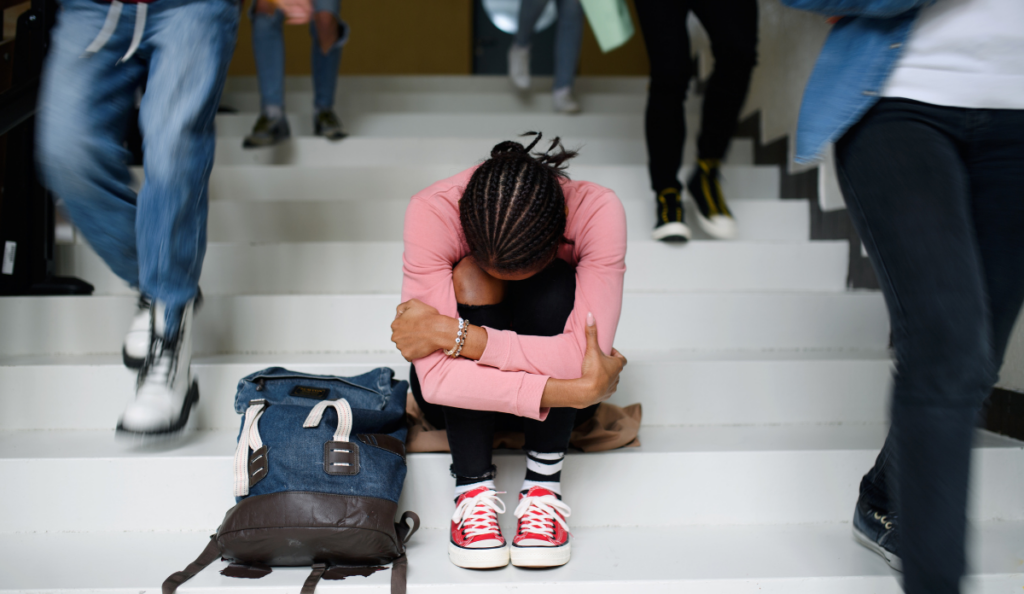 a woman sitting on stairs with her head in her hands