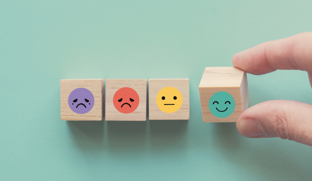 a hand holding a block with emojis on it