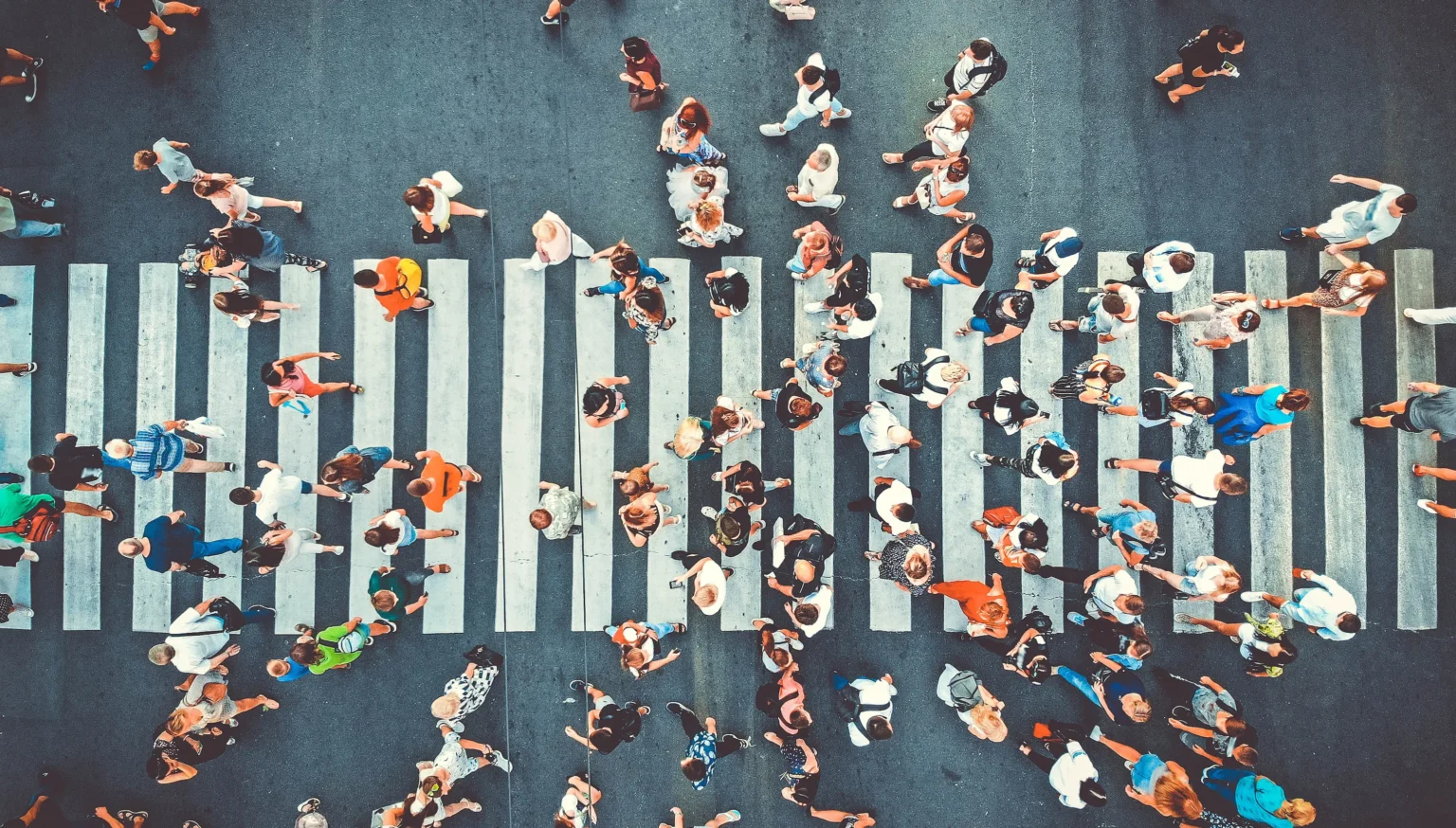 Aerial view of people crossing a street in a city.