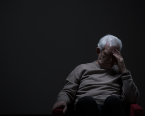 Despairing older man on a dark background