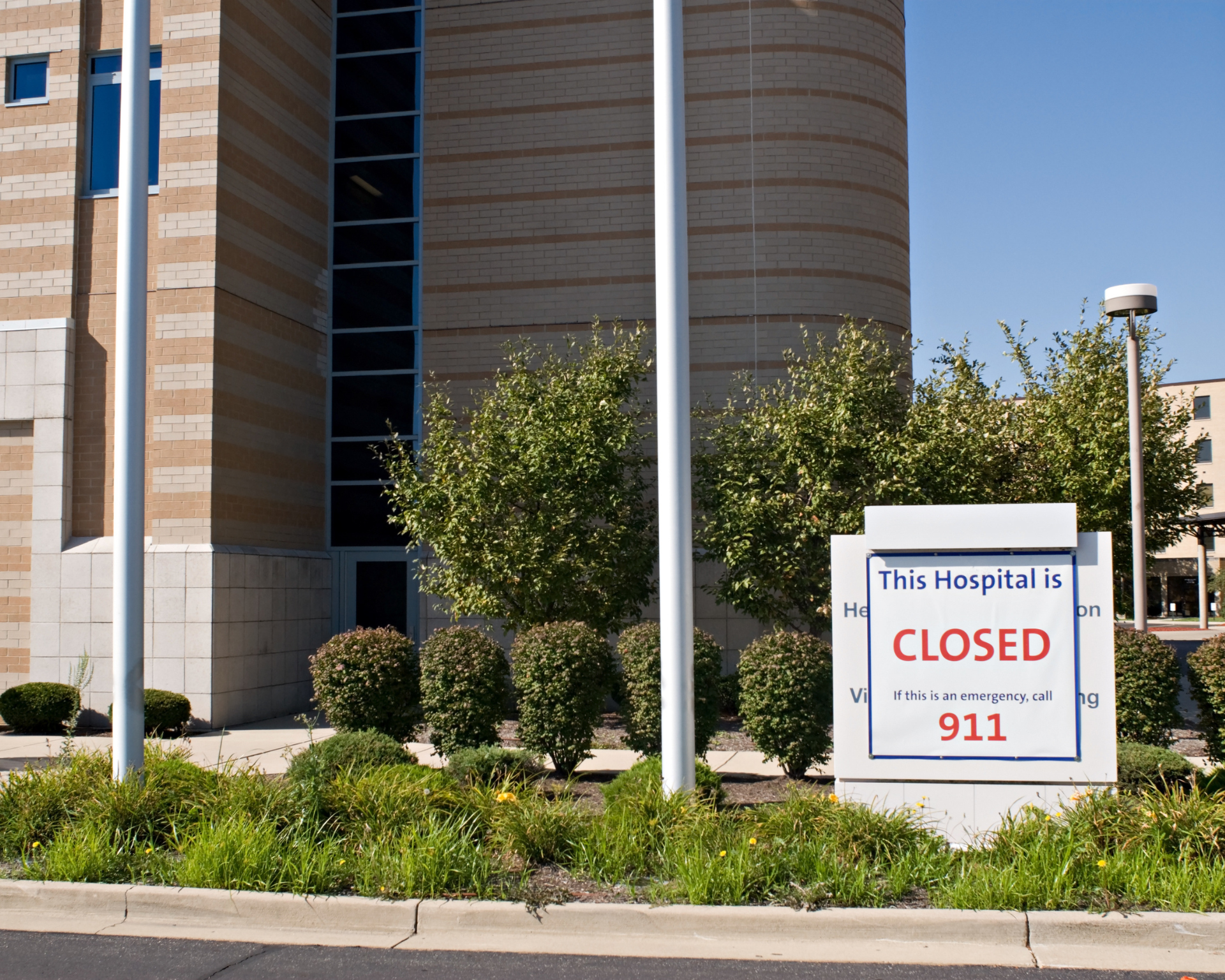 Rural hospital facility with a 'Closed' sign out front