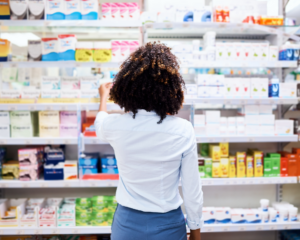 Rearview shot of a young woman looking at a variety of products in a pharmacy aisle