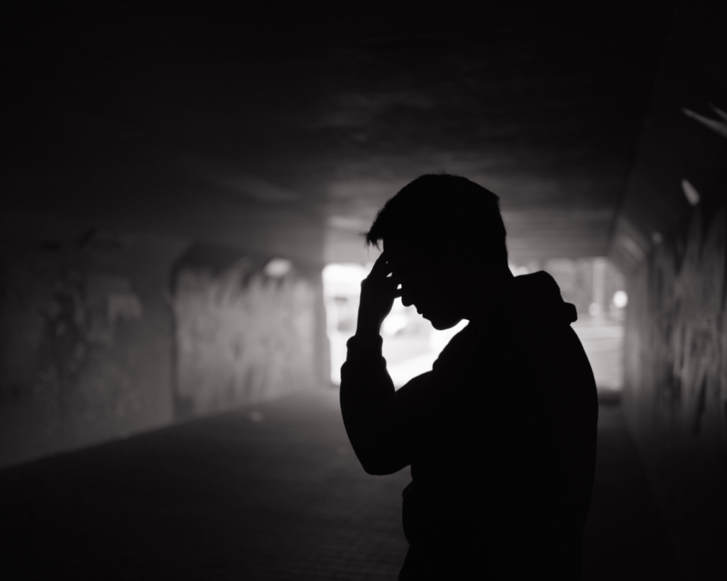 Shadow of a stressed, poverty-stricken man standing in alley