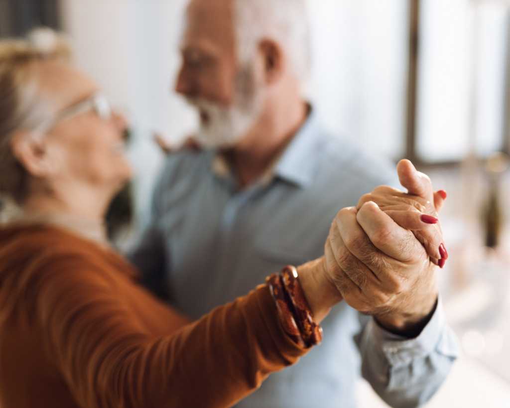 Close-up of older couple holding hands while dancing