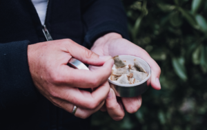 Close up image of hands grabbing a pouch of smokeless tobacco out of a container