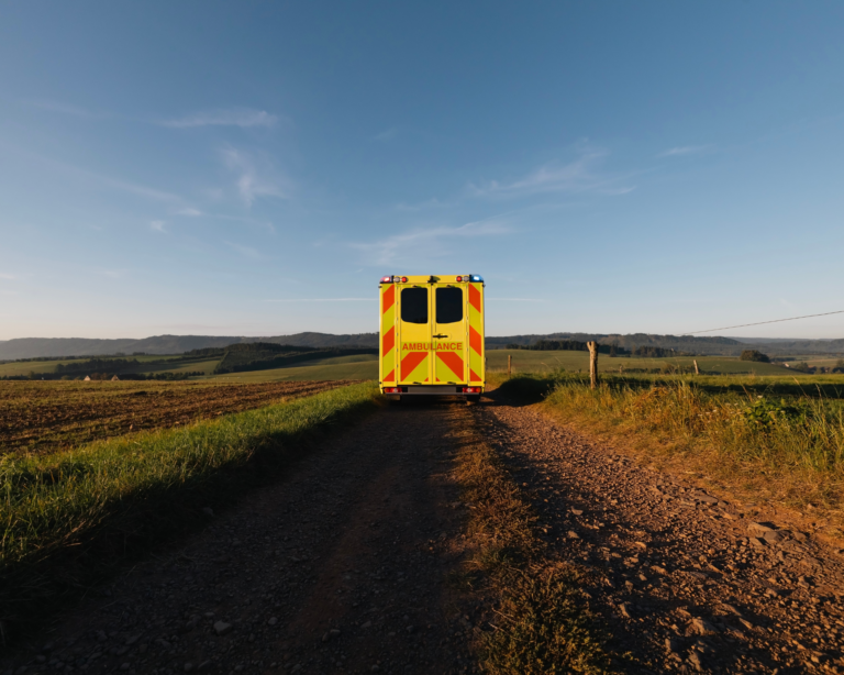 Emergency medical vehicle on rural dirt road. Opioid overdose in rural settings concept