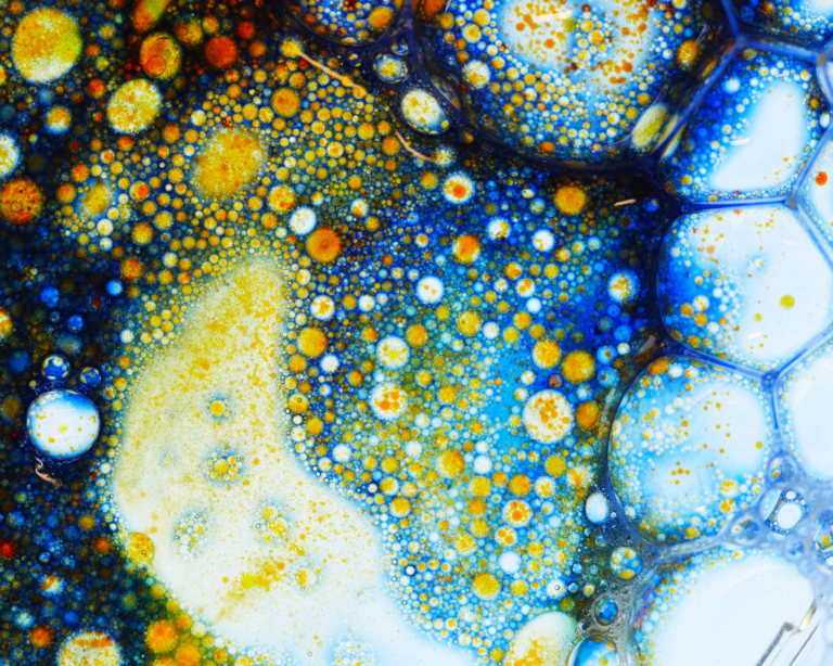 Petri dish with close up colourful detailed bubbles on a white background