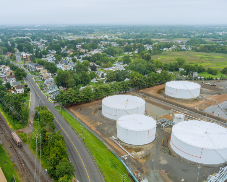 Aerial panoramic view of a small town near oil refinery industrial tanks