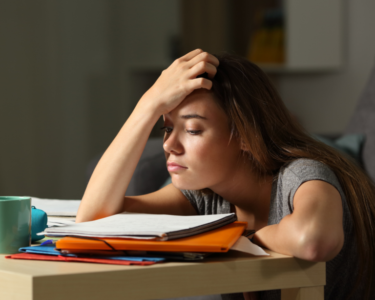 young girl doing schoolwork, running on limited sleep