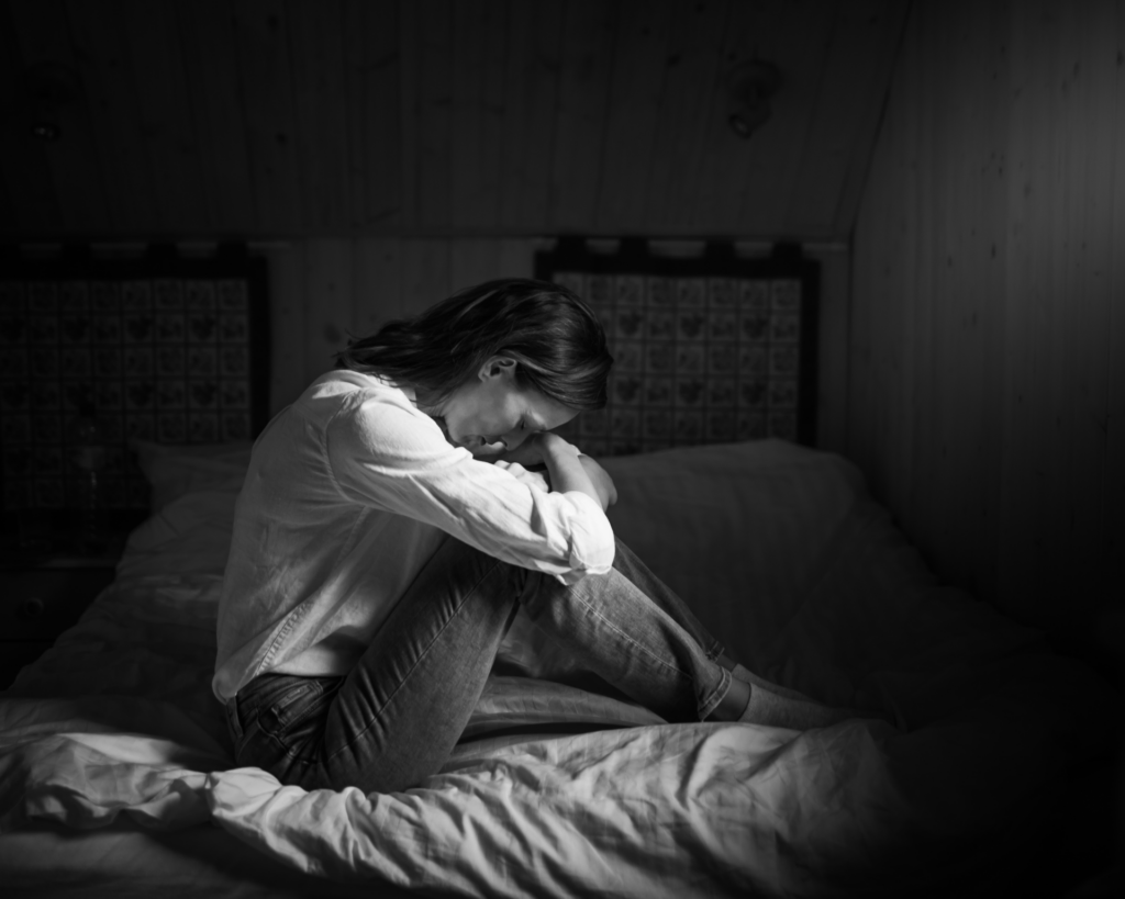 Lonely tired stressed woman alone in a dark room