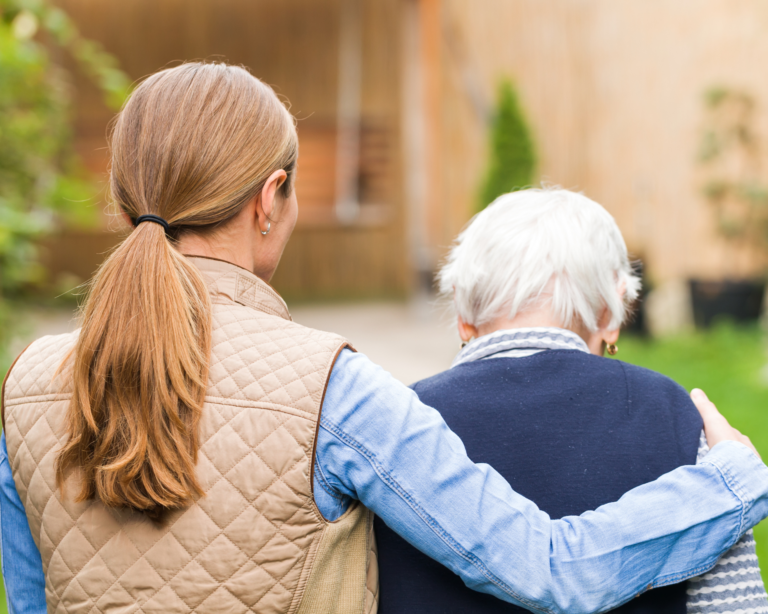 Young caregiver walking with elderly woman