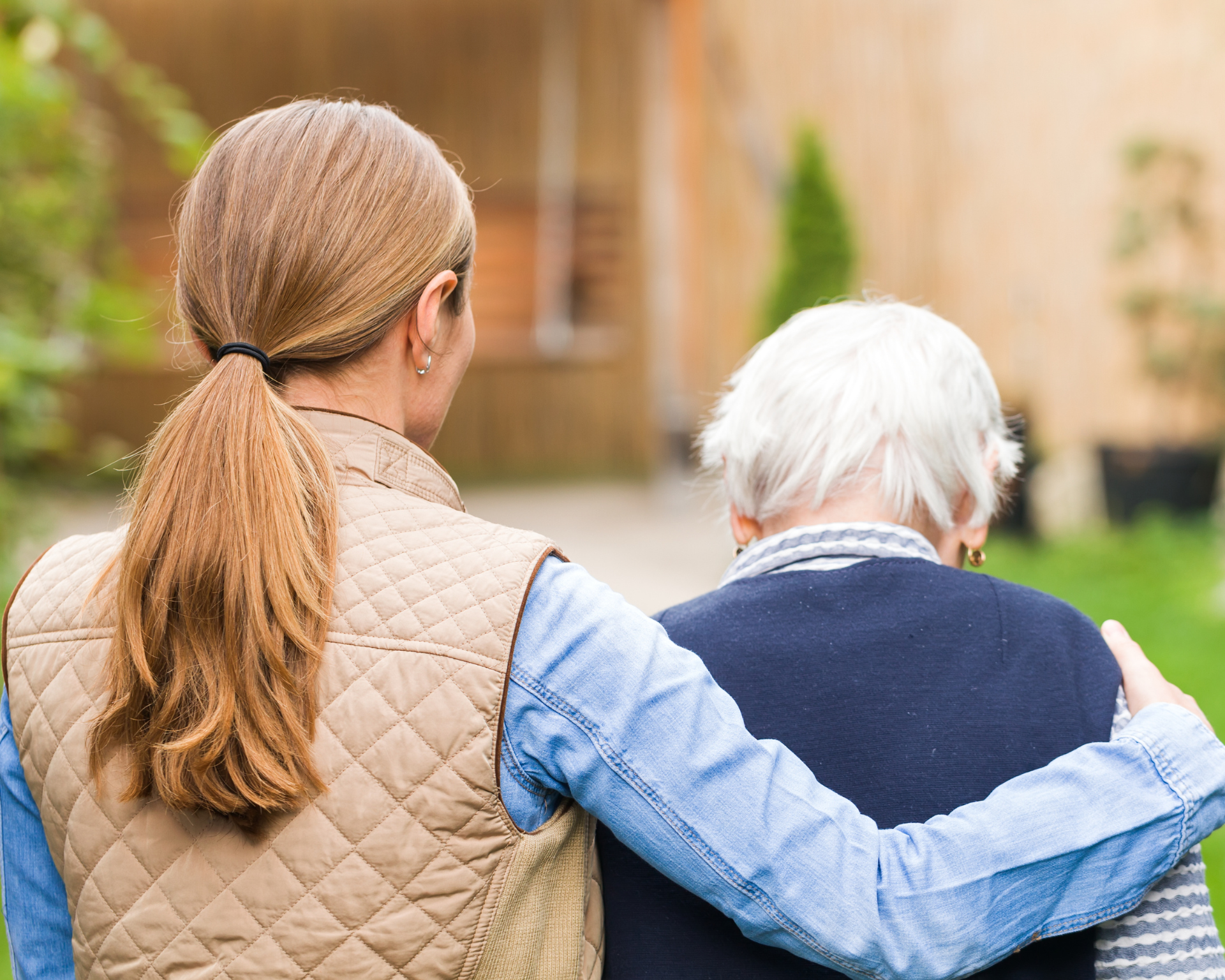 Young caregiver walking with elderly woman