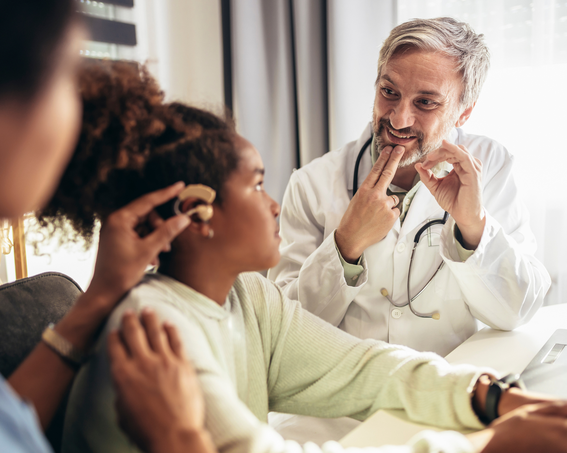 doctor using ASL to communicate with young, deaf patient